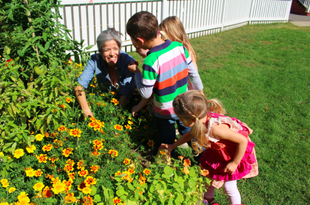 Marcella Kapsaroff, PIFS mom and Garden Committee Chair shows children the fruits of their gardens.
